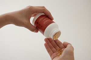hands and vitamin bottle