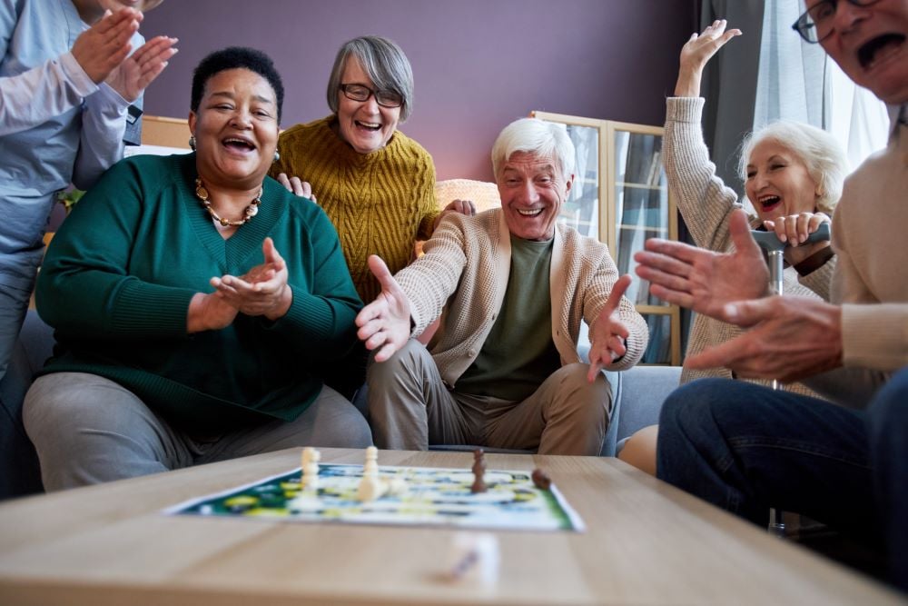 excited-senior-people-playing-board-games-at-retir-2023-11-27-05-02-29-utc