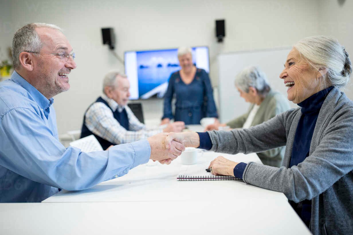 senior-citizens-meeting-at-skill-enhencement-course-shaking-hands-WESTF24670